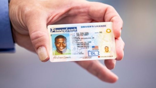 A close-up image of a hand holding a Pennsylvania driver's license